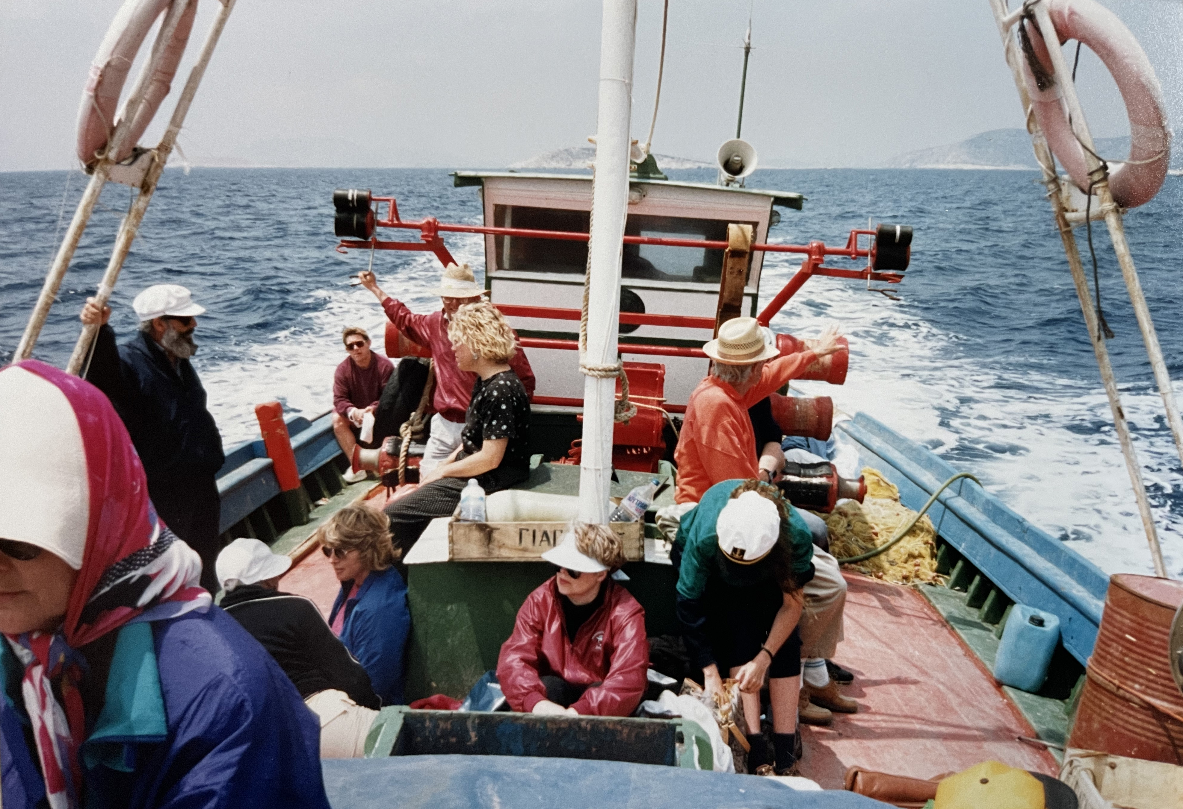 Picture of people riding on a traditional Caique fishing boat on the island of Amogos